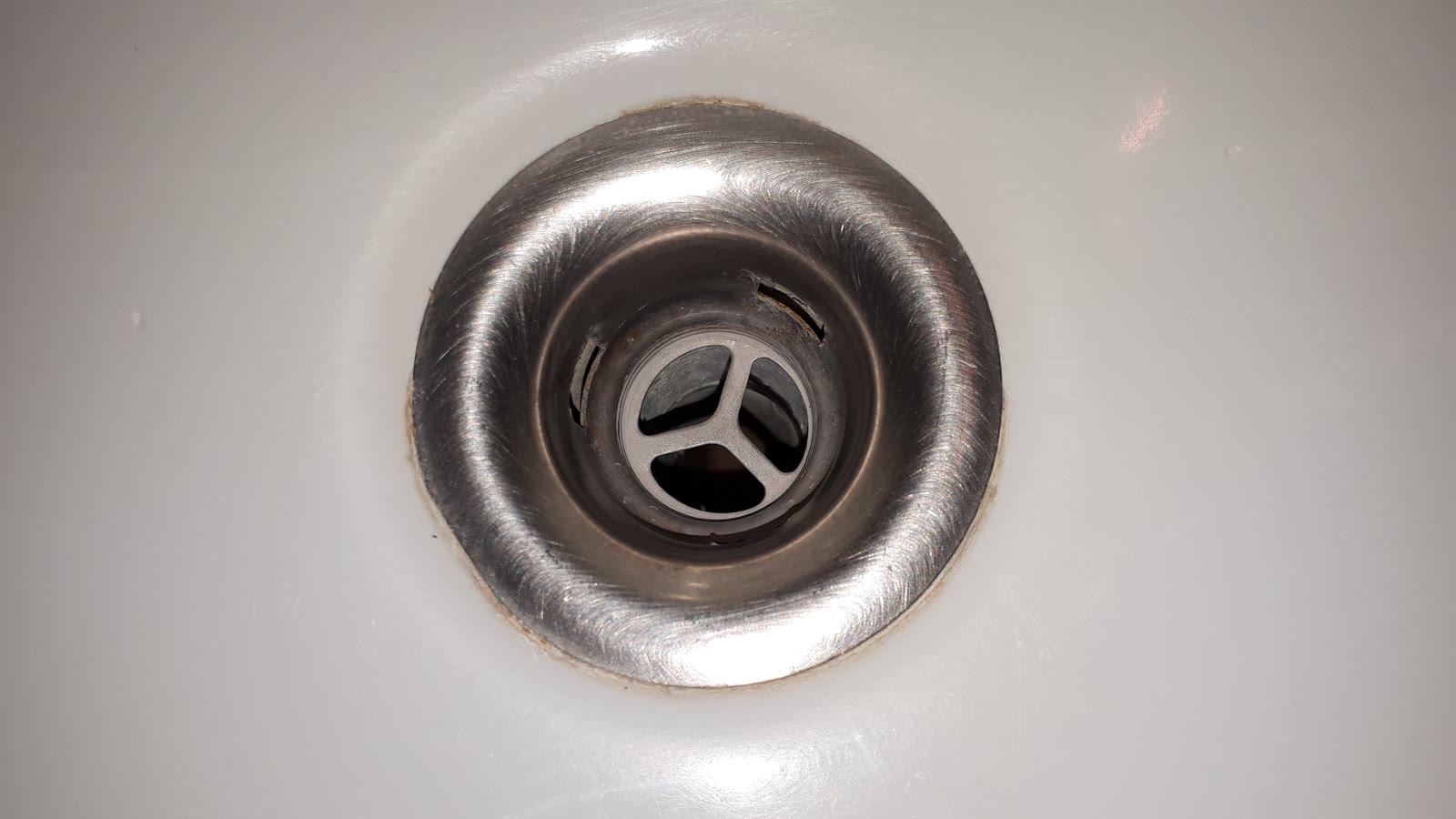 Bonde de lavabo vue de près avant nettoyage de l’évacuation