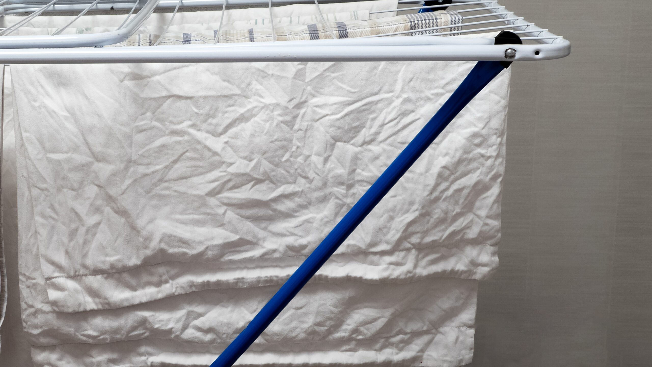 Linge blanc qui sèche sur un étendoir à l’intérieur d’un logement
