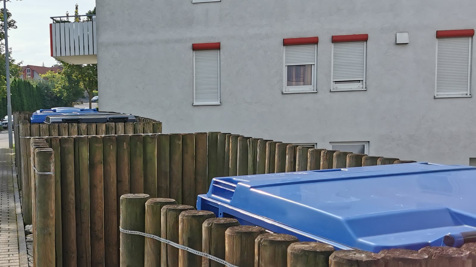 Local poubelles extérieur de copropriété avec bacs de tri