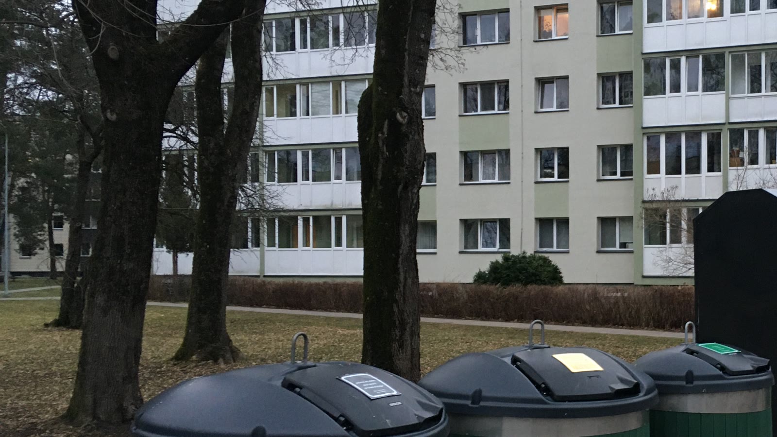 Bacs de tri près d’un immeuble résidentiel