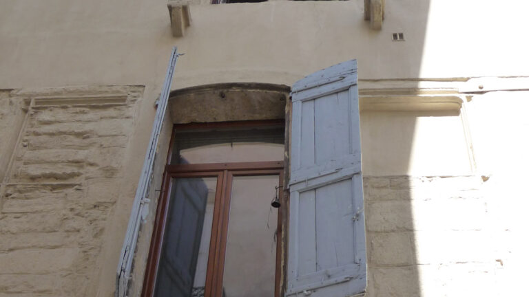 Façade ancienne avec fenêtres et volets à inspecter