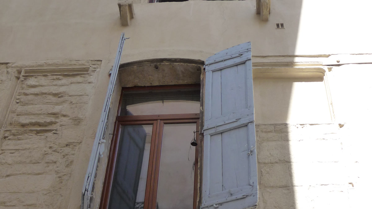 Façade ancienne avec fenêtres et volets à inspecter