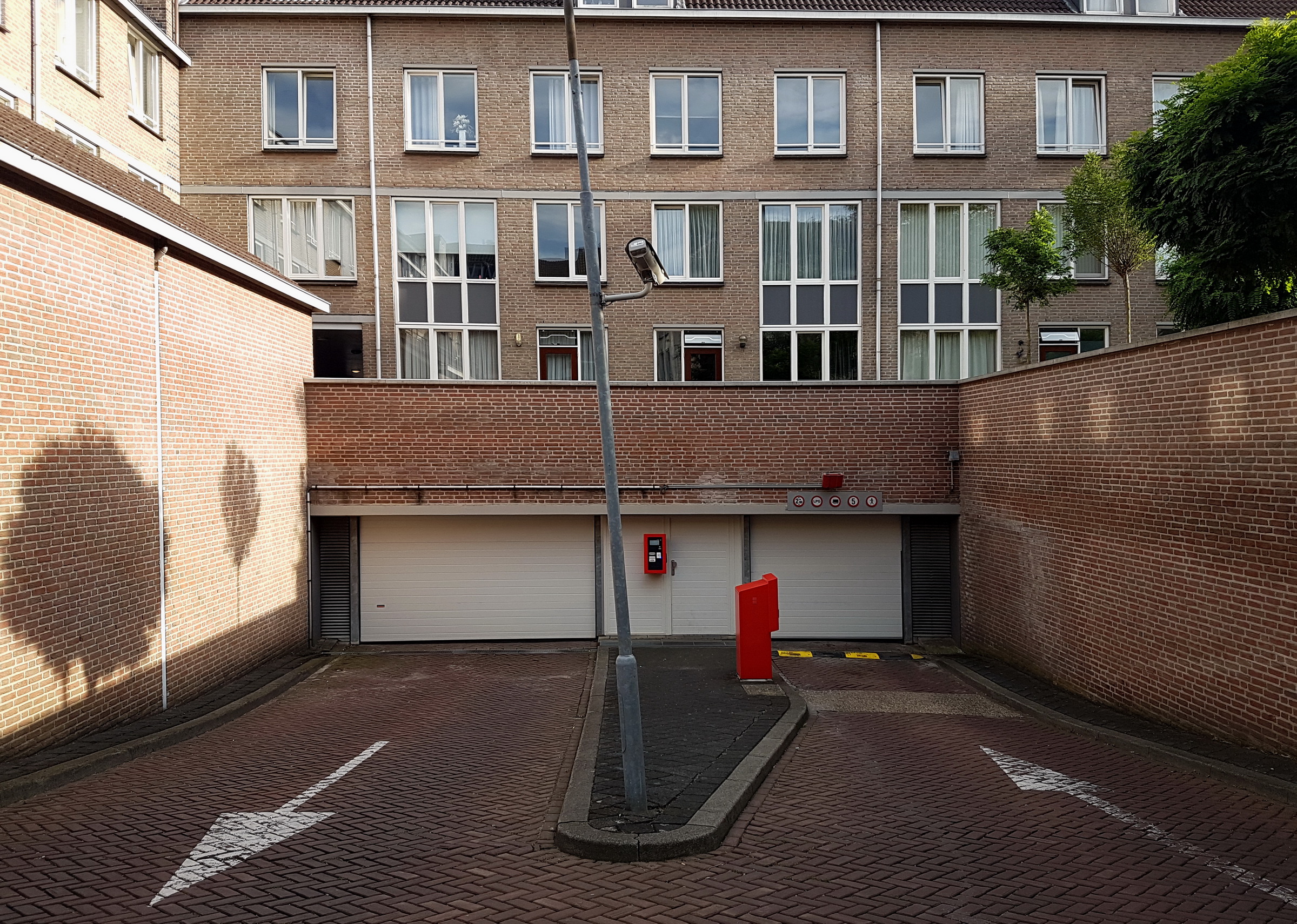 Accès de parking résidentiel avec portail et barrière à surveiller