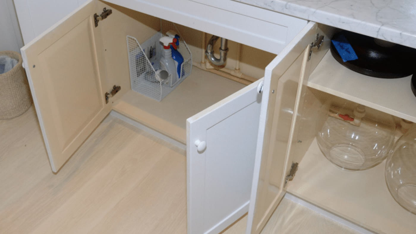 Produits ménagers rangés sous un évier de salle de bain