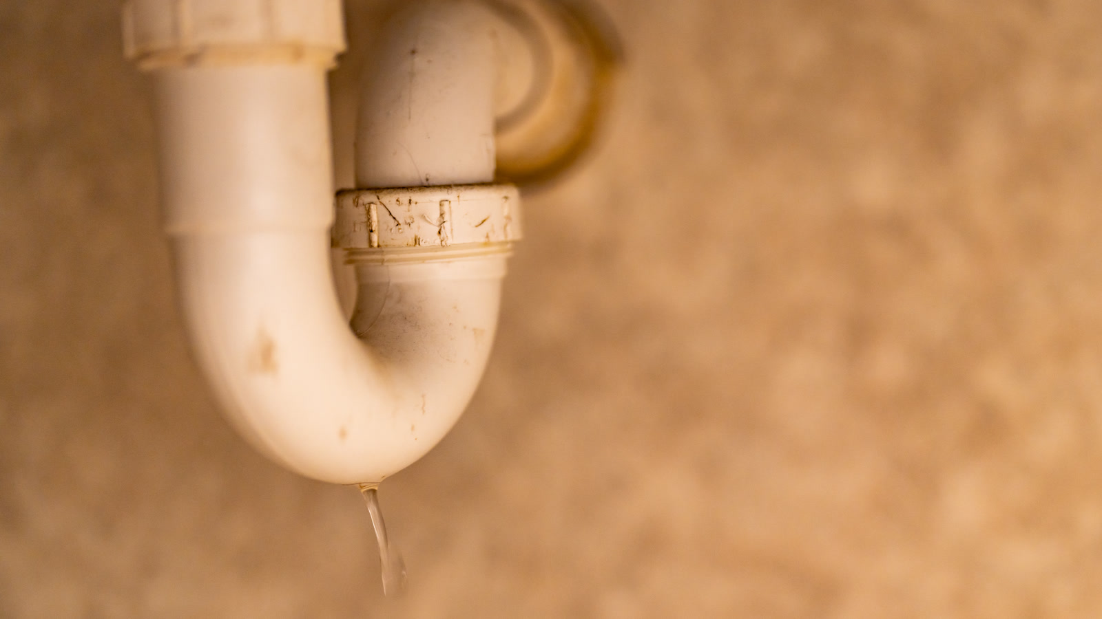 Siphon sous évier avec une goutte d’eau visible