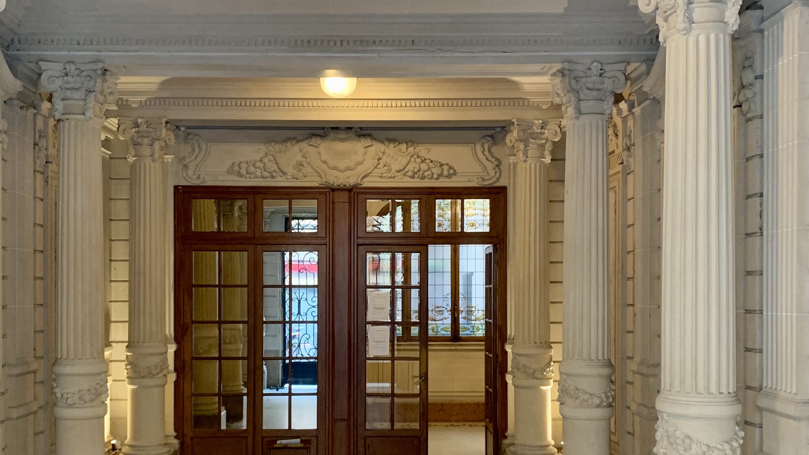 Hall d’entrée d’immeuble entretenu avec sol propre et colonnes